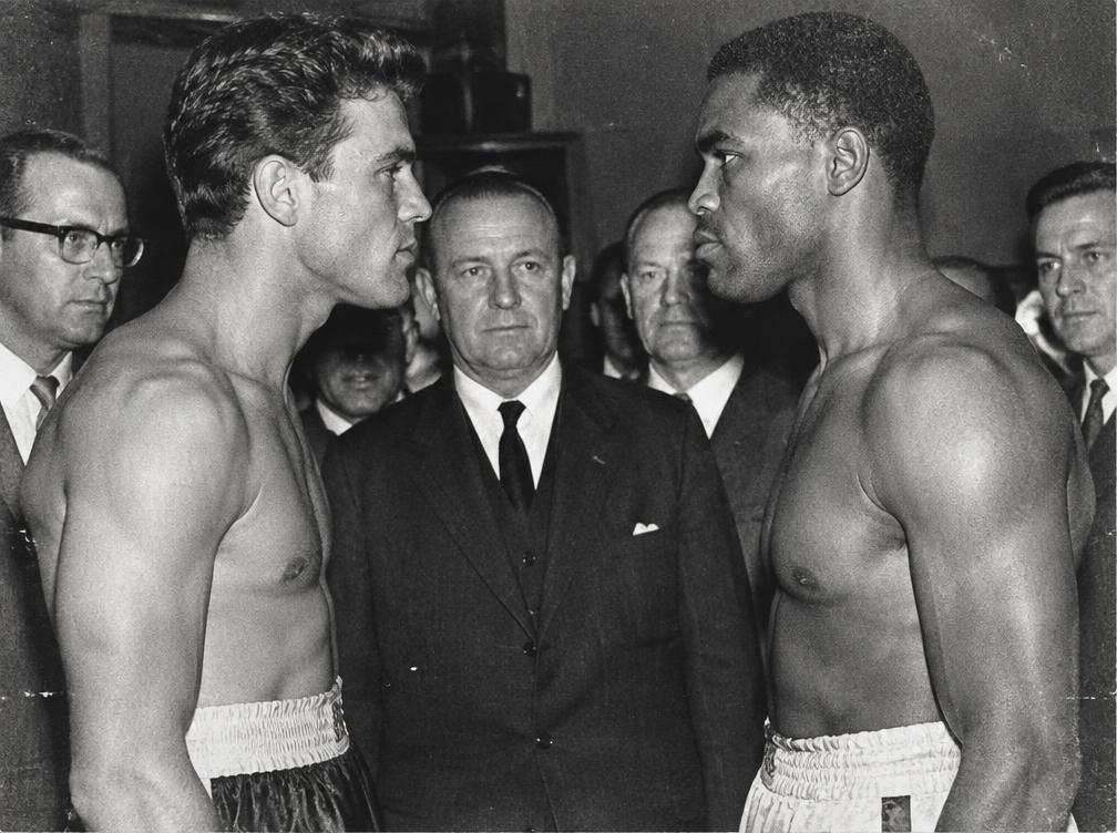 Two boxers facing off at a weigh-in